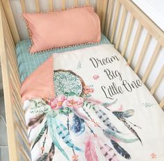 a baby crib with a blanket and pillow in it