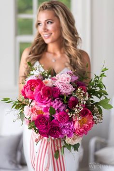 a woman holding a large bouquet of flowers