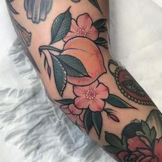 a close up of a person's leg with tattoos on it and flowers around the legs