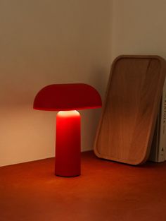 a red lamp sitting on top of a wooden table