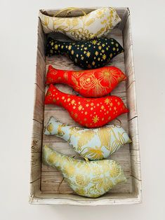 four decorative pillows in a wooden box