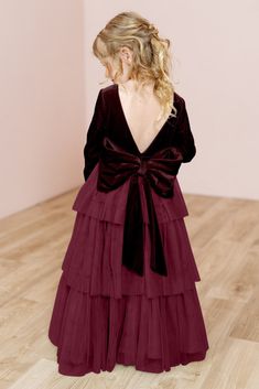 the back of a woman's dress with long sleeves and a bow at the waist