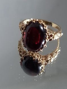 Absolutely stunning genuine natural Garnet ring. Please find for sale an extremely fine 9ct gold large heavy Victorian style cabochon garnet ring. The ring weighs 5.4grams. It has makers mark NK. It is fully hallmarked. Set with a beautiful large cabochon Garnet, of stunning colour approx 5ct. Also exceptional gold work. The face of the ring measures 13 x 9mm. The ring weighs 5.4grams heavy . It is ring size O 1/2 / USA size 7 1/2 and is offered in good condition Such a beautiful eye catching an Large Garnet Ring, Antique Garnet Ring, Antique Gold Ring, Dark Rings, Rings Vintage, Beautiful Eye, Victorian Rings, Ring Antique, Cabochon Ring