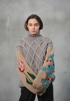 a woman wearing a sweater with flowers on it