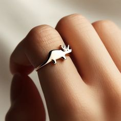 *Free engravings up to 20 characters* Unleash the ancient wonder with this intriguing minimalist triceratops ring! 🌟 It's a graceful adornment for your finger or a splendid gift for that cherished one who's captivated by the prehistoric realm and the grandeur of dinosaurs. 🦖💚 Let's stomp into versatility; this ring is superb for stacking or making a statement on its own, crafting a bold yet captivating allure. Meticulously designed, it features a minimalist triceratops design along a delicate band, capturing the essence of this mighty herbivore from a time long past. It's as stylish as it is evocative, ready to accompany you through daily explorations or adventurous journeys into the ancient world. Whether you're celebrating the majestic legacy of dinosaurs or simply in search of that u Dinosaur Ring, Dinosaur Jewelry, Dinosaur Bones, Dinosaur Design, Ring Dainty, Gift Jewelry, Jewelry Inspo, Yellow Gold Rings, Rings Statement