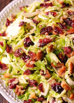 a salad with lettuce, cranberries and pecans