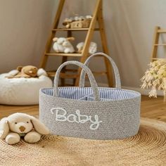 a baby basket sitting on top of a rug next to a stuffed animal