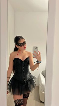 a woman in a black corset taking a selfie with her cell phone