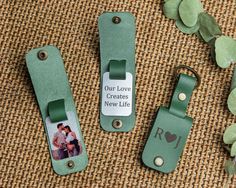 two green luggage tags with the words our love creates a new life on them next to some leaves