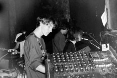 two young men standing next to each other in front of mixing equipment