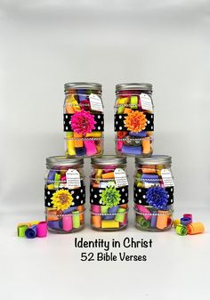 several small jars filled with different types of colorful beads and flowers on top of each other