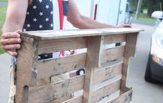 a man holding a wooden crate with an american flag on it's back and his hand