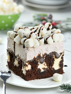 a piece of cake with marshmallows and chocolate on top sitting on a plate