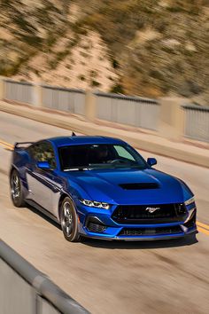 a blue sports car driving down the road