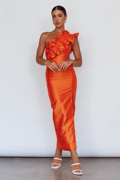 a woman in an orange dress posing for the camera with her hands on her hips