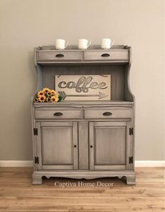 a gray hutch with two cups on top and a sign above it that says coffee