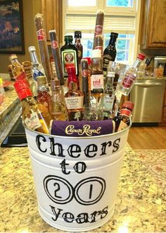 a bucket filled with liquor bottles and condiments sitting on top of a counter