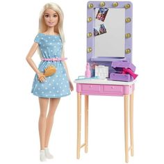 a barbie doll standing next to a vanity and mirror