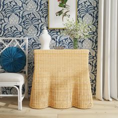 a white vase sitting on top of a table next to a blue and white wall