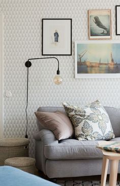 a living room filled with furniture and framed pictures on the wall above it's couch