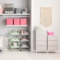 a baby's room with pink and gray accessories on shelves, white rugs and drawers