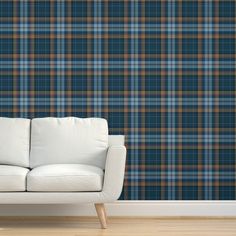 a couch sitting in front of a wall with a blue and purple plaid pattern on it