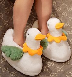 a pair of white slippers with yellow and green ducks on them, sitting on a carpet