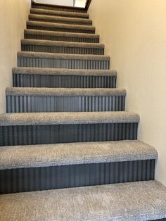 a set of stairs leading up to the top floor in a home with carpeted steps