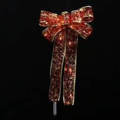 a red and gold bow with lights on it