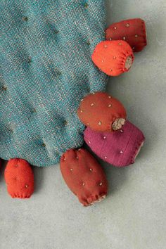 several small stuffed animals sitting on top of a blue cloth covered pillow with holes in the fabric