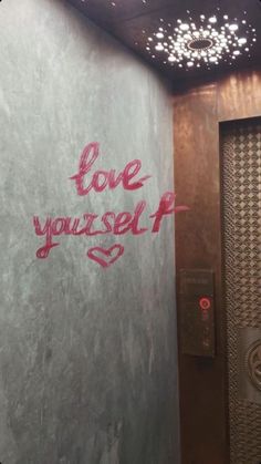 graffiti on the side of a wall that says love yourself and is next to a door