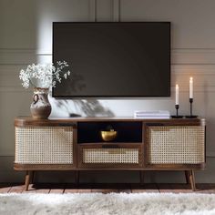 an entertainment center with wicker furniture and a large flat screen tv mounted on the wall