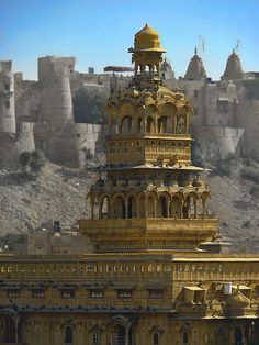 an elaborately designed building in the middle of a desert with mountains in the background