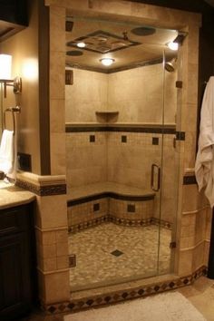 a bathroom with a walk in shower next to a sink and mirror on the wall