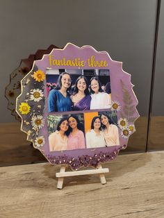 an ornate photo frame with three women and flowers in the center on a wooden table