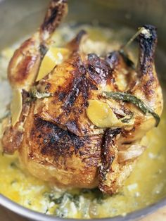 a close up of a chicken in a pan on a table with broccoli