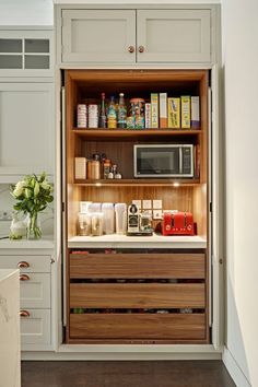 an open cabinet in the middle of a kitchen