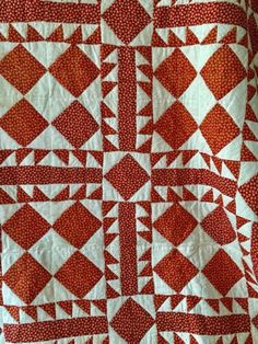 an orange and white quilt with squares on it