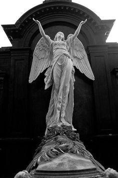 an angel statue stands in front of a building