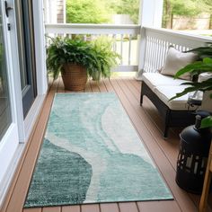 a porch with a rug and potted plants on it