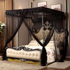 a black canopy bed sitting on top of a wooden floor next to a white rug