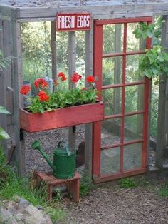 a garden shed with flowers in it and a sign that says fresh eggs on the door