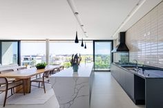 a modern kitchen and dining room with large windows