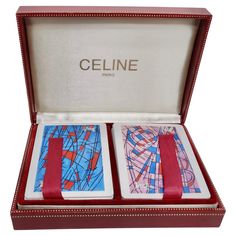 two playing cards in a red box with the word celine printed on one side