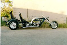 a black and white motorcycle parked on the side of a road next to a building