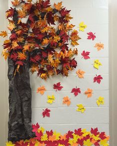 a bulletin board with fall leaves on it and a tree made out of tissue paper