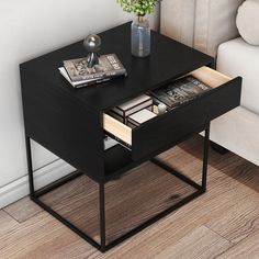 a table with magazines and a vase on it next to a couch in a living room