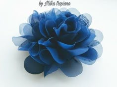 a blue flower is shown on a white surface