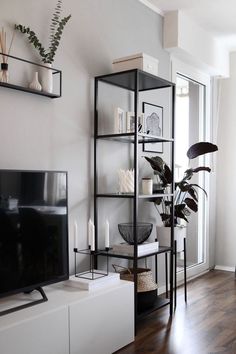 a living room filled with furniture and a flat screen tv sitting on top of a wooden floor