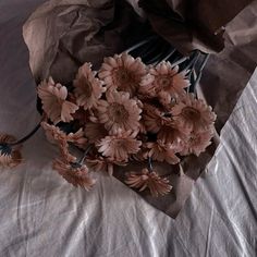 a bunch of pink flowers sitting on top of a bed